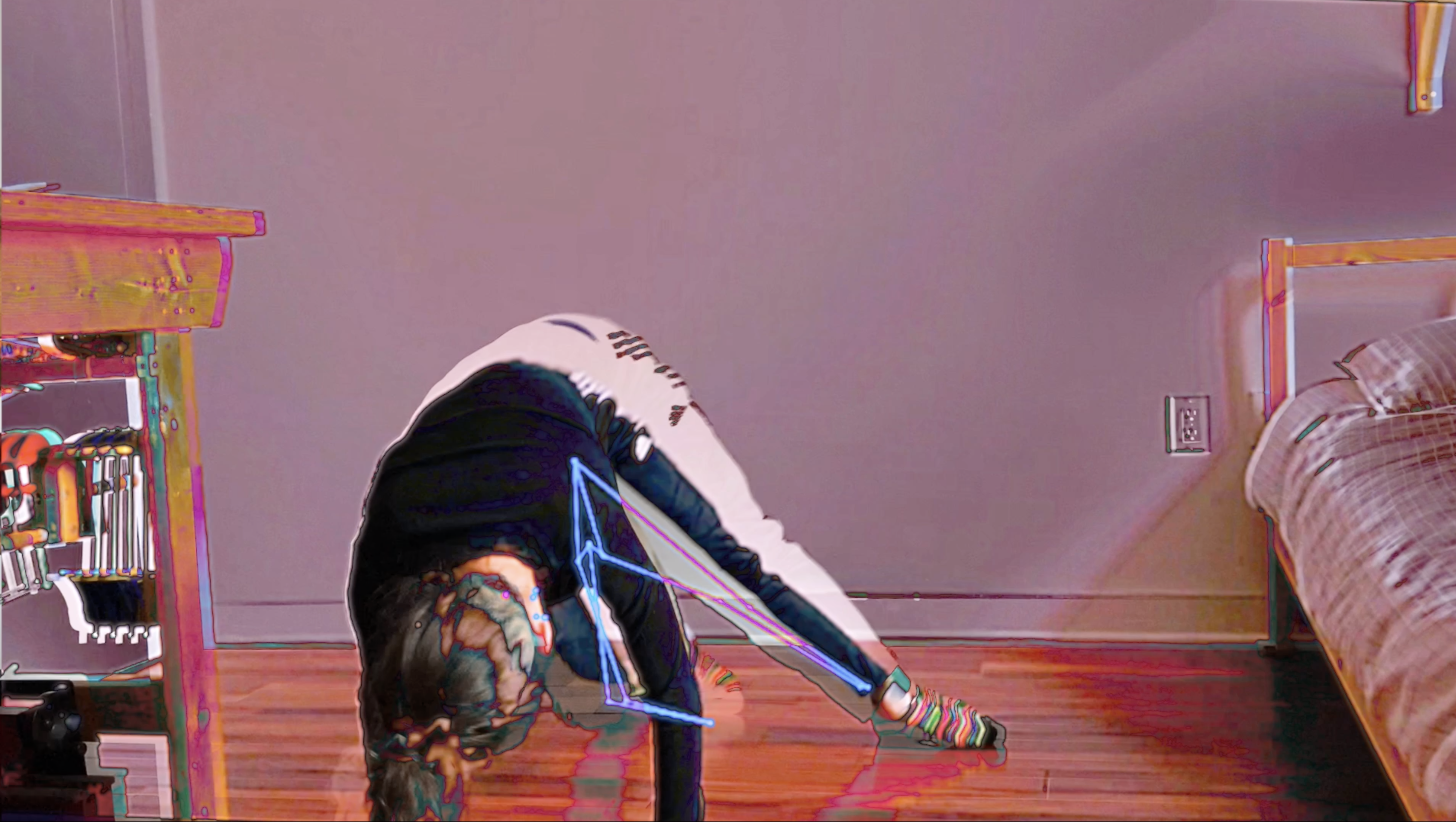 A dancer poses with all hands and feet on the ground, the weight in their front hands and their head bowed down. Their right leg is extended toward the right side of the image, towards a a bed that extends into the frame. A bookcase is partially visible in the left side of the image. Glitchy computer lines cover the dancer's figure, and the entire image is cast in a pinkish hue. Credit is as follows: Time Enough: Clock: November 2020 (Looptime), created by Allison Costa with PoseNet motion capture.