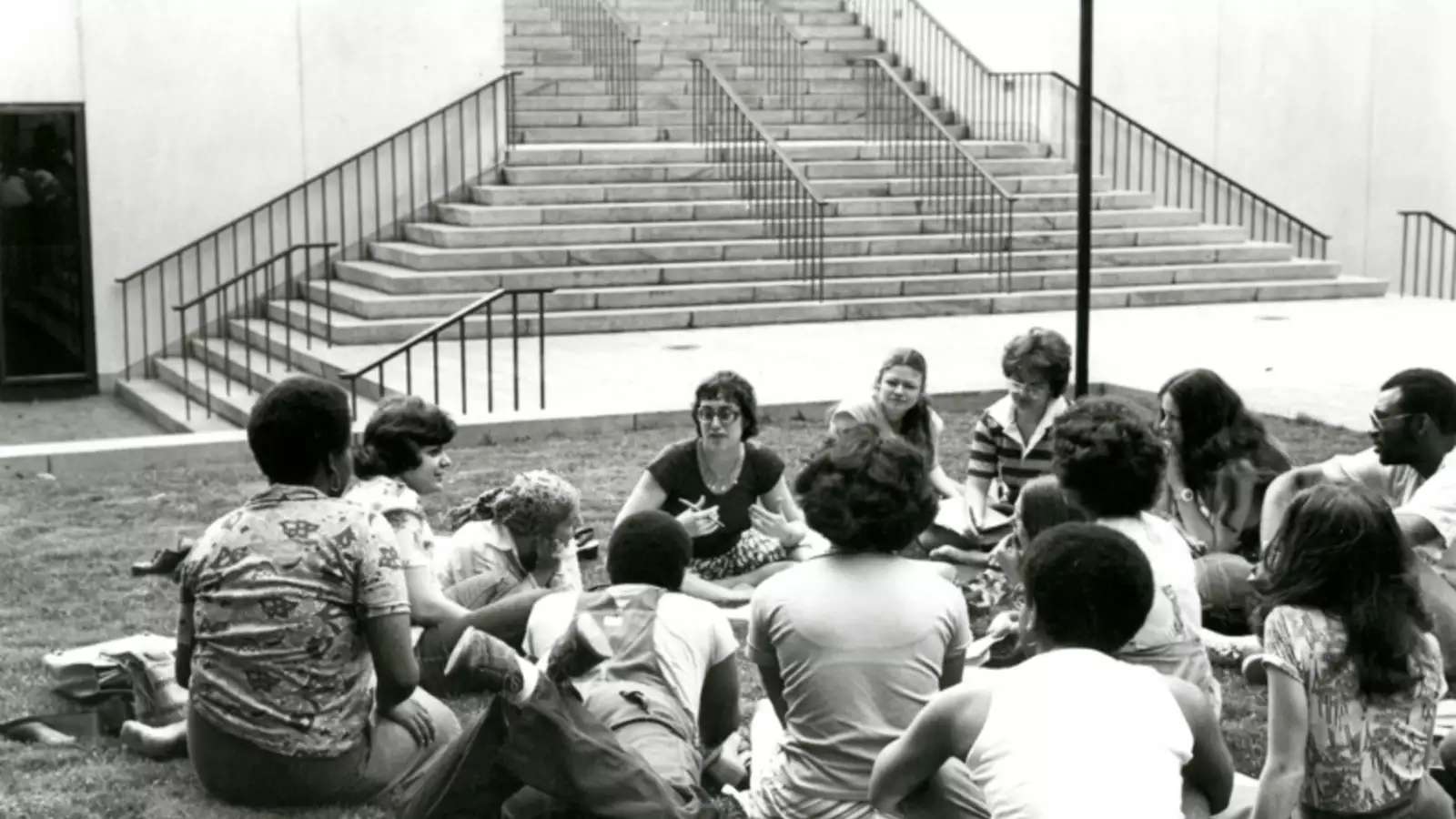 An environmental humanities class meets outside. The photo is black and white. 