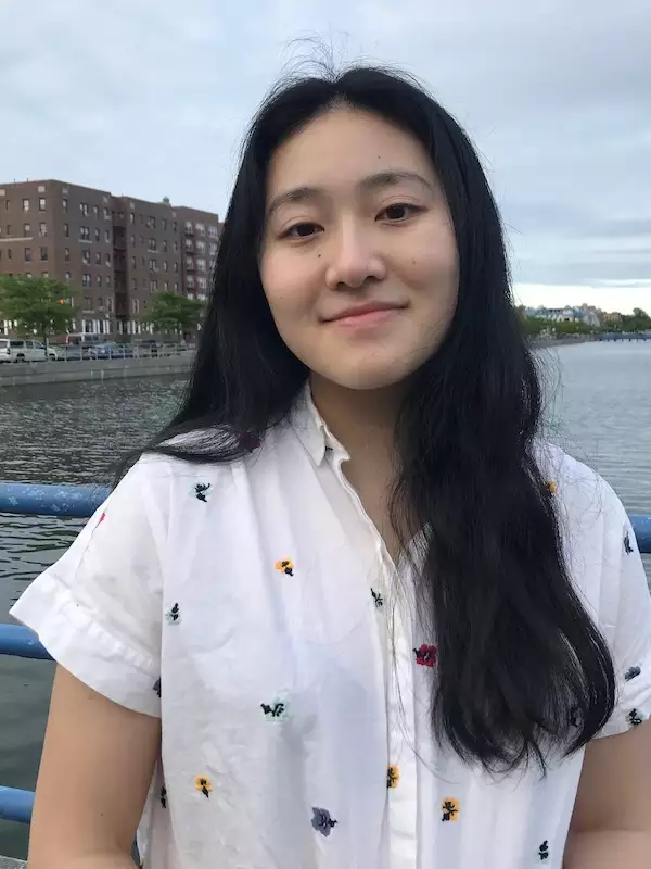 Kayla is in a white shirt standing in front of water