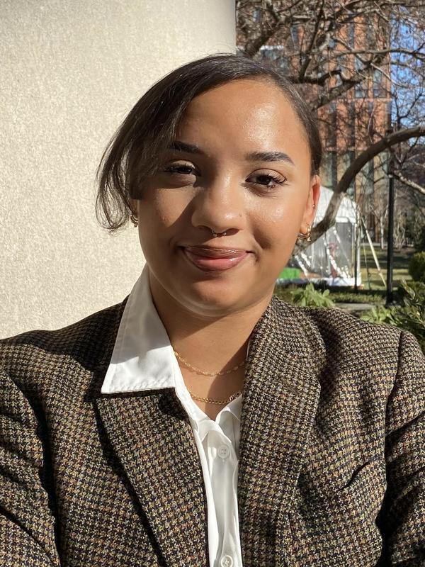 Image of Janelle Matias, CEP student intern wearing a blazer and collared shirt and standing on the Barnard campus