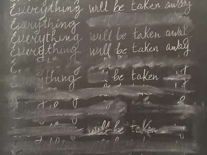 A detail from Adrian Piper's "Everything #21." It features the phrase "Everything will be taken away" written 25 times in cursive (and partially erased) on a blackboard.