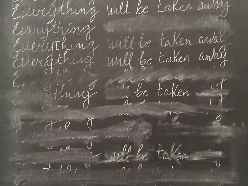 A detail from Adrian Piper's "Everything #21." It features the phrase "Everything will be taken away" written 25 times in cursive (and partially erased) on a blackboard.