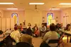 People sitting in chairs in a circle listening to a peer talk